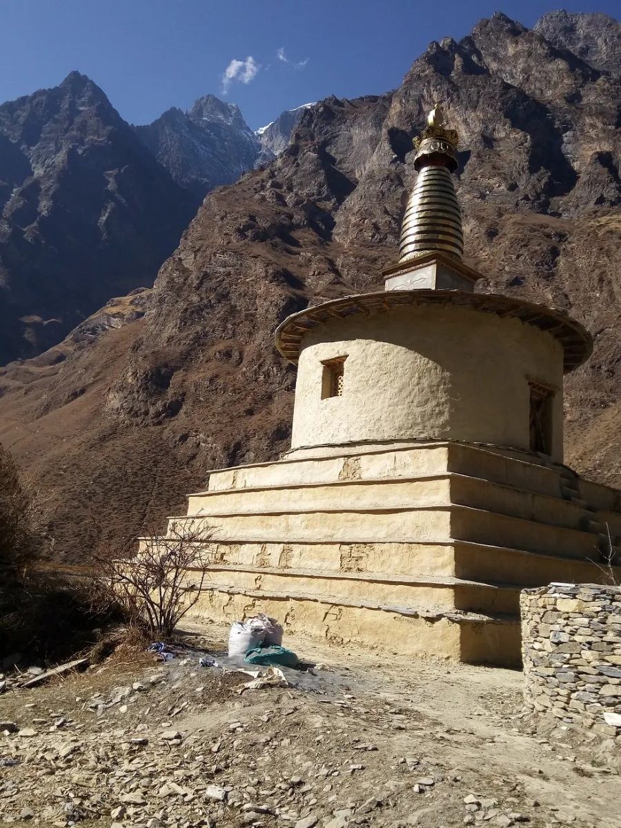 Traditional Buddhist stupa surrounded by Himalayan landscapes in the remote Tsum Valley of Nepal.