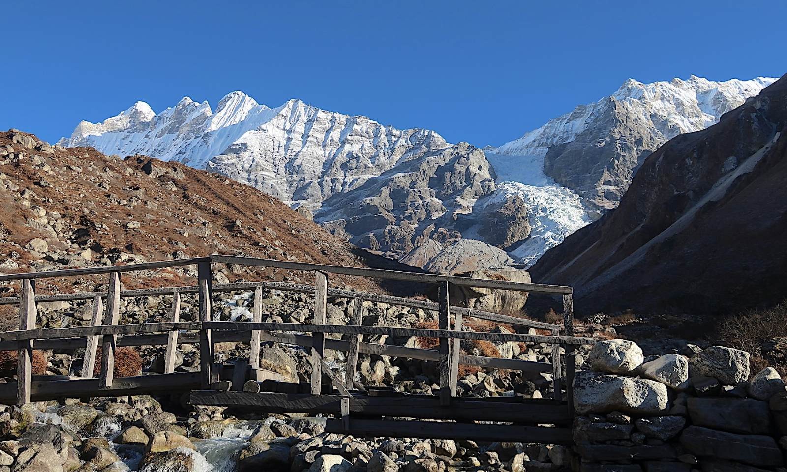 Mountain wooden bridge Langtang trekking route Nepal Himalayan trail