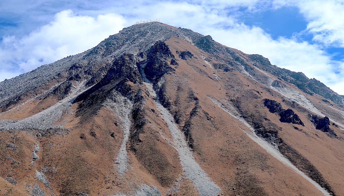 Trekkers standing on the summit of Tserko Ri with panoramic views of Langtang Lirung, glaciers, snow-covered Himalayan peaks, and the beautiful Langtang Valley below.