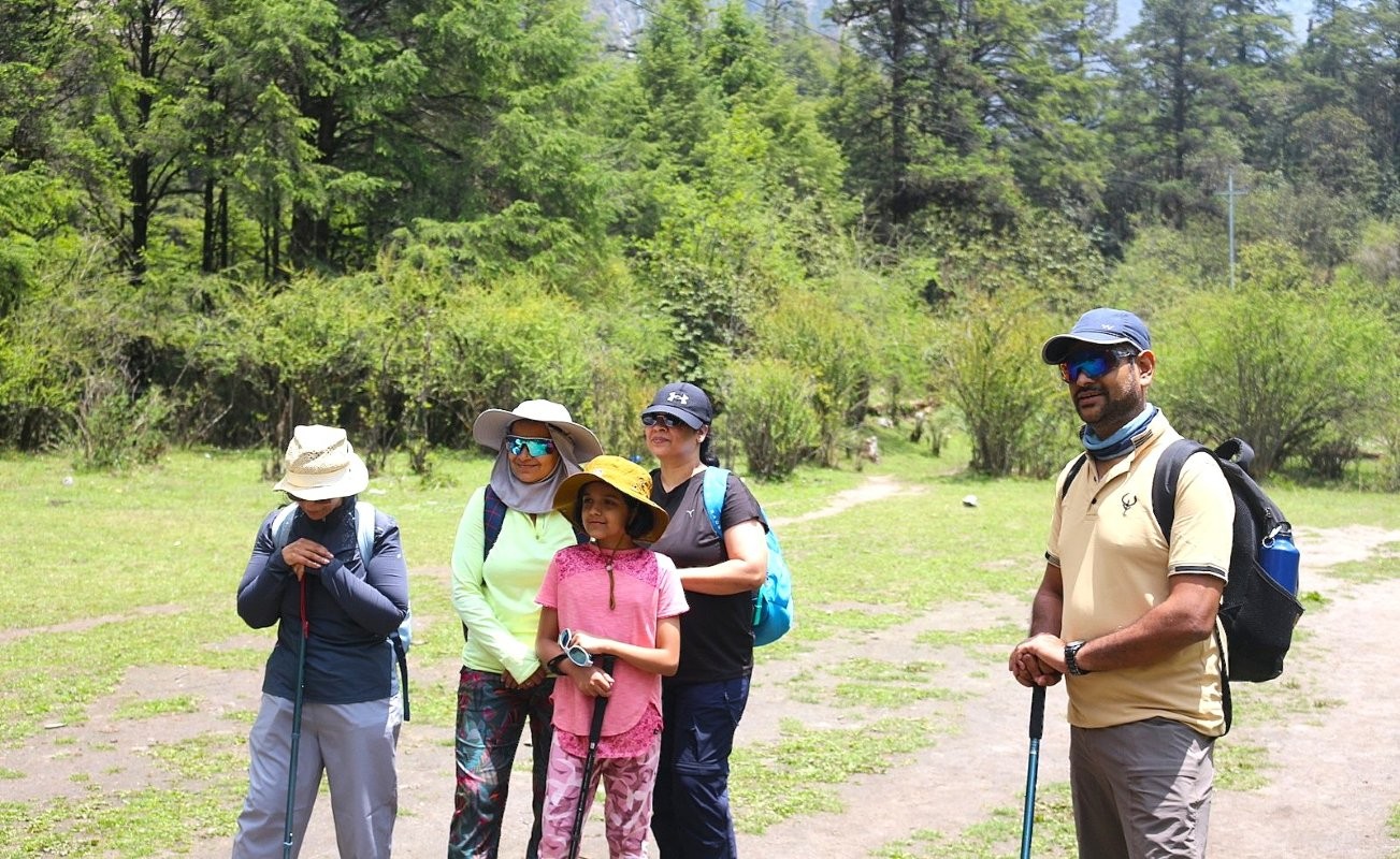 Beginner trekkers with children hiking along the Langtang Valley trail surrounded by Himalayan mountains