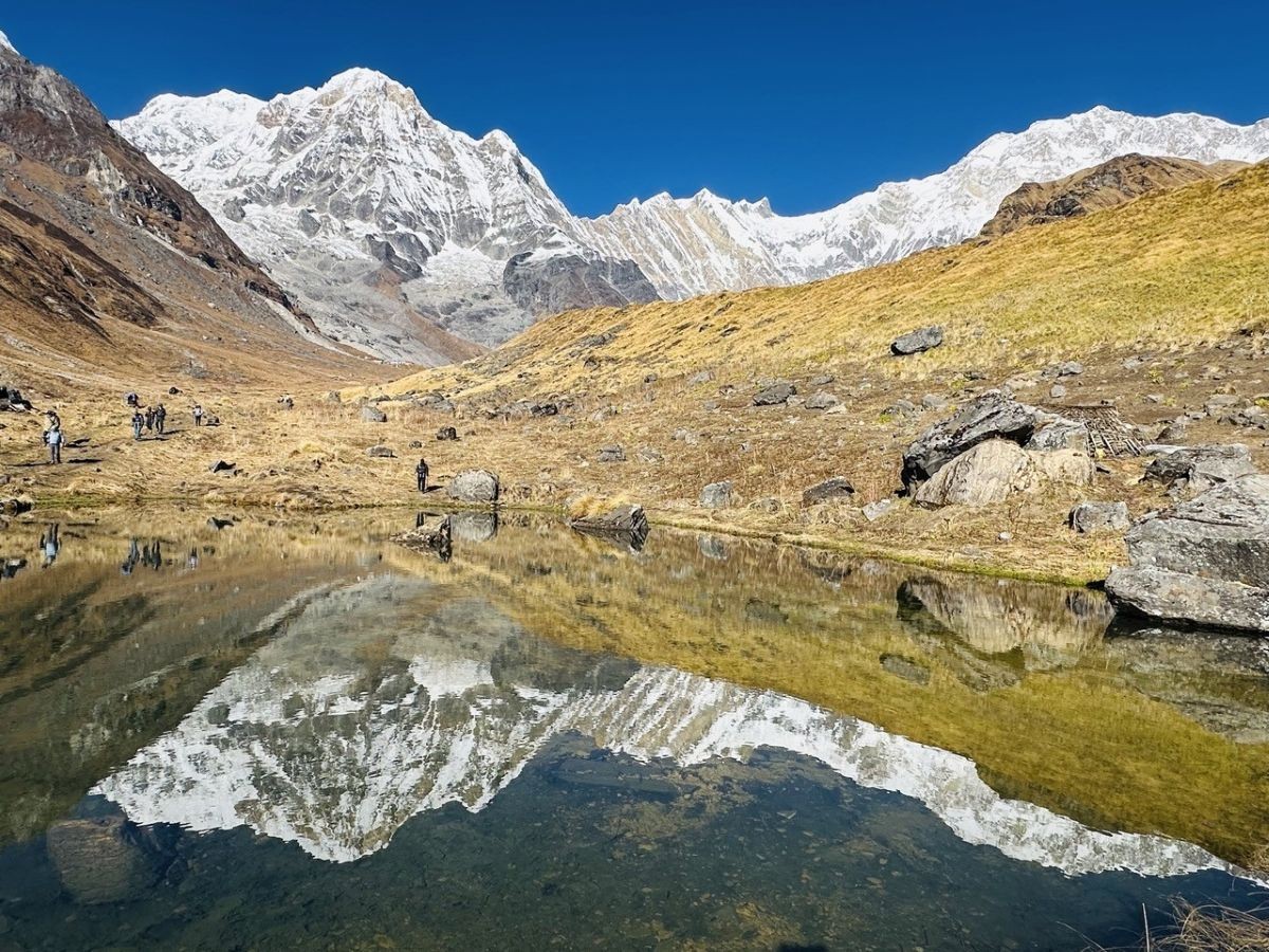 Annapurna mountain reflections in a tranquil alpine lake during the autumn trekking season