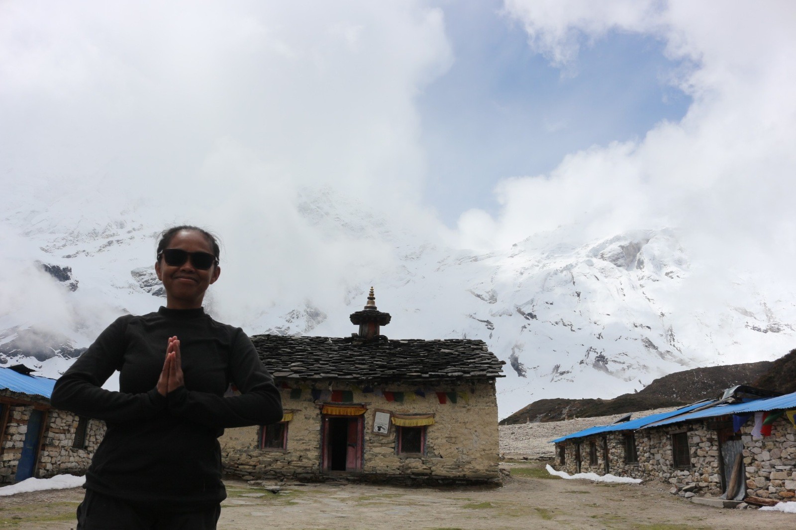Pungyen Monastery on the Manaslu Circuit Trek, the traditional stone-built monastery, surrounded by snow-covered Himalayan peaks and drifting September clouds.