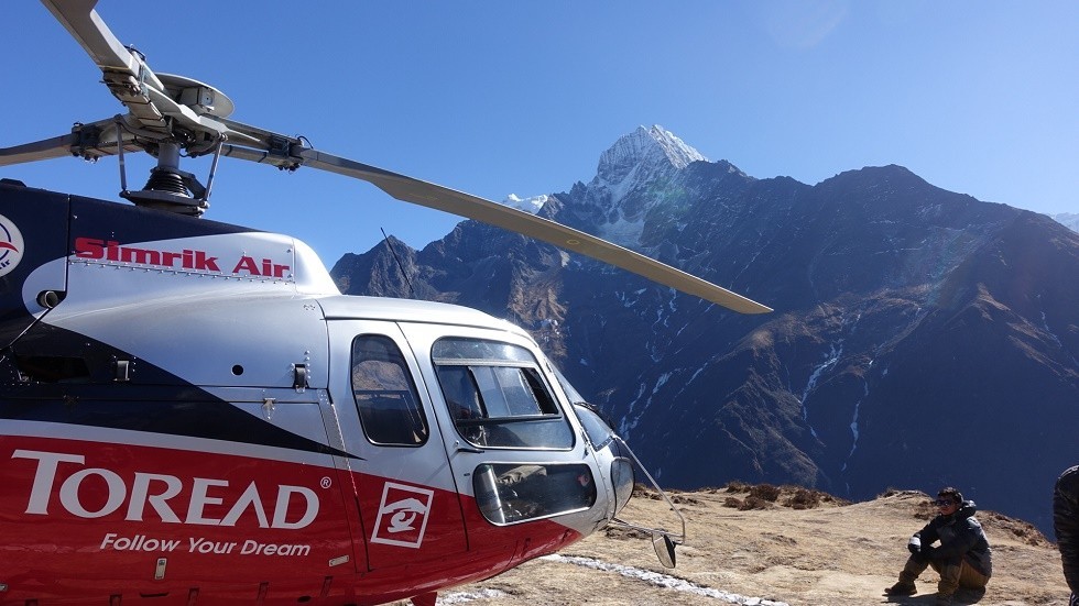 Helicopter flying over the Khumbu Valley with Mount Thamserku towering above the Himalayan landscape during the Everest Base Camp Trek
