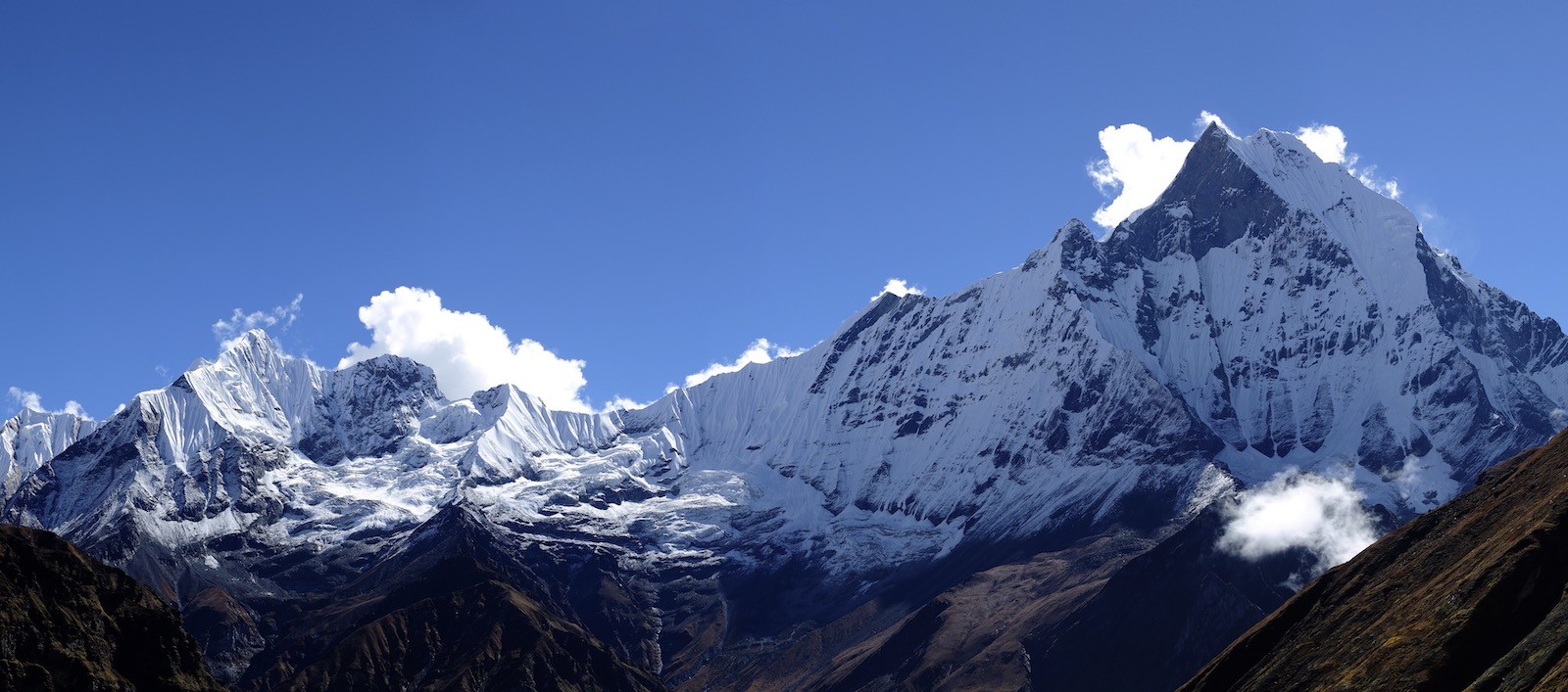 Machapuchare (Fishtail Mountain) towering above Annapurna Base Camp with snow-covered peaks under a clear Himalayan sky.