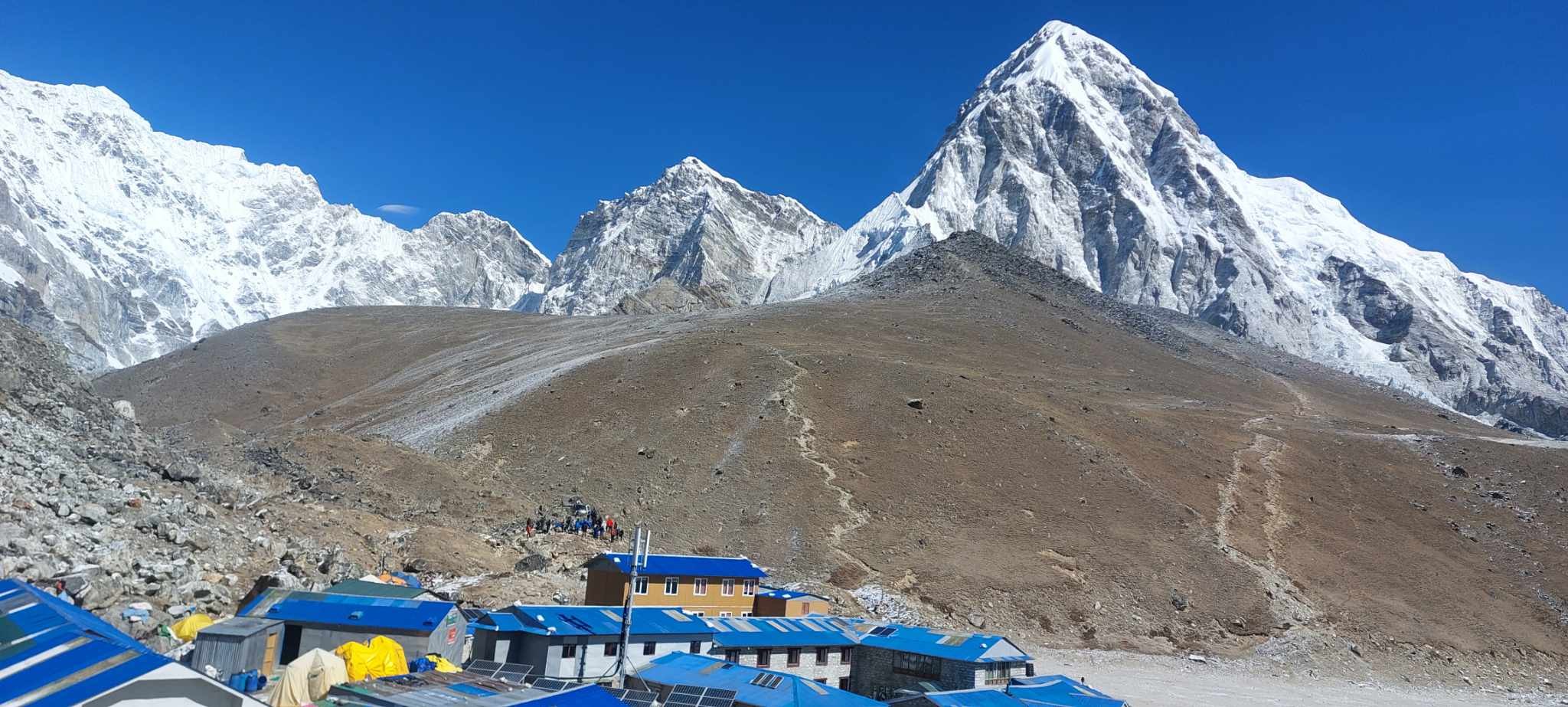 Gorak Shep village with mountain lodges beneath the towering pyramid of Pumori (7,161 m), surrounded by glaciers and rugged Himalayan landscapes on the Everest Base Camp Trek.