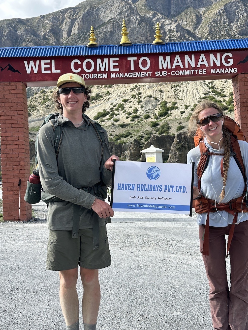 Welcome gate to Manang village on the Annapurna Circuit Trek, featuring a traditional stone entrance, colorful prayer flags, Himalayan architecture, and spectacular mountain views in Nepal.