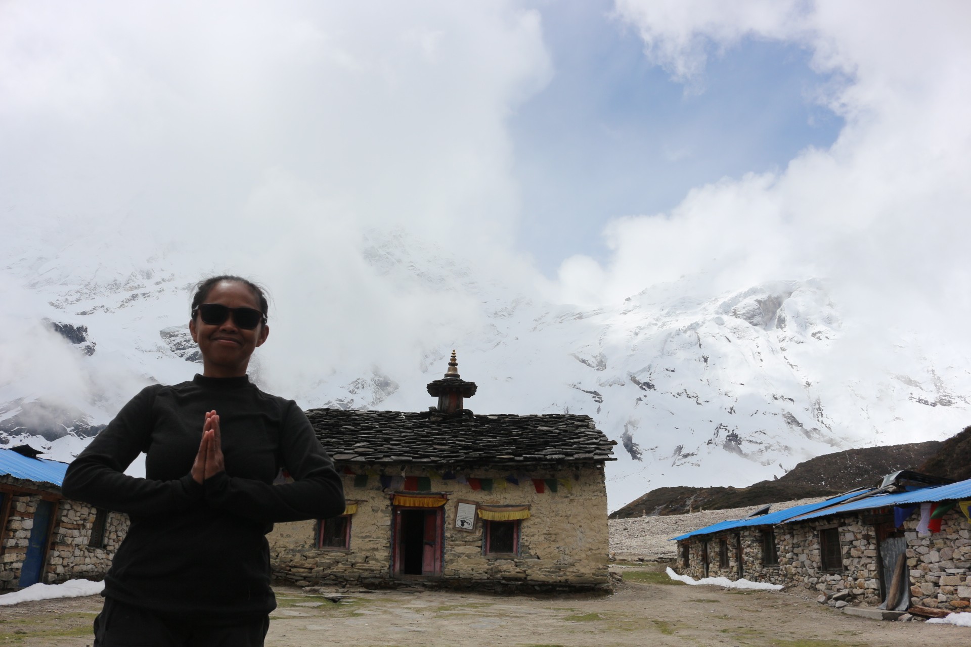 Pungyen Monastery on the Manaslu Circuit Trek, the traditional stone-built monastery, surrounded by snow-covered Himalayan peaks and drifting September clouds.