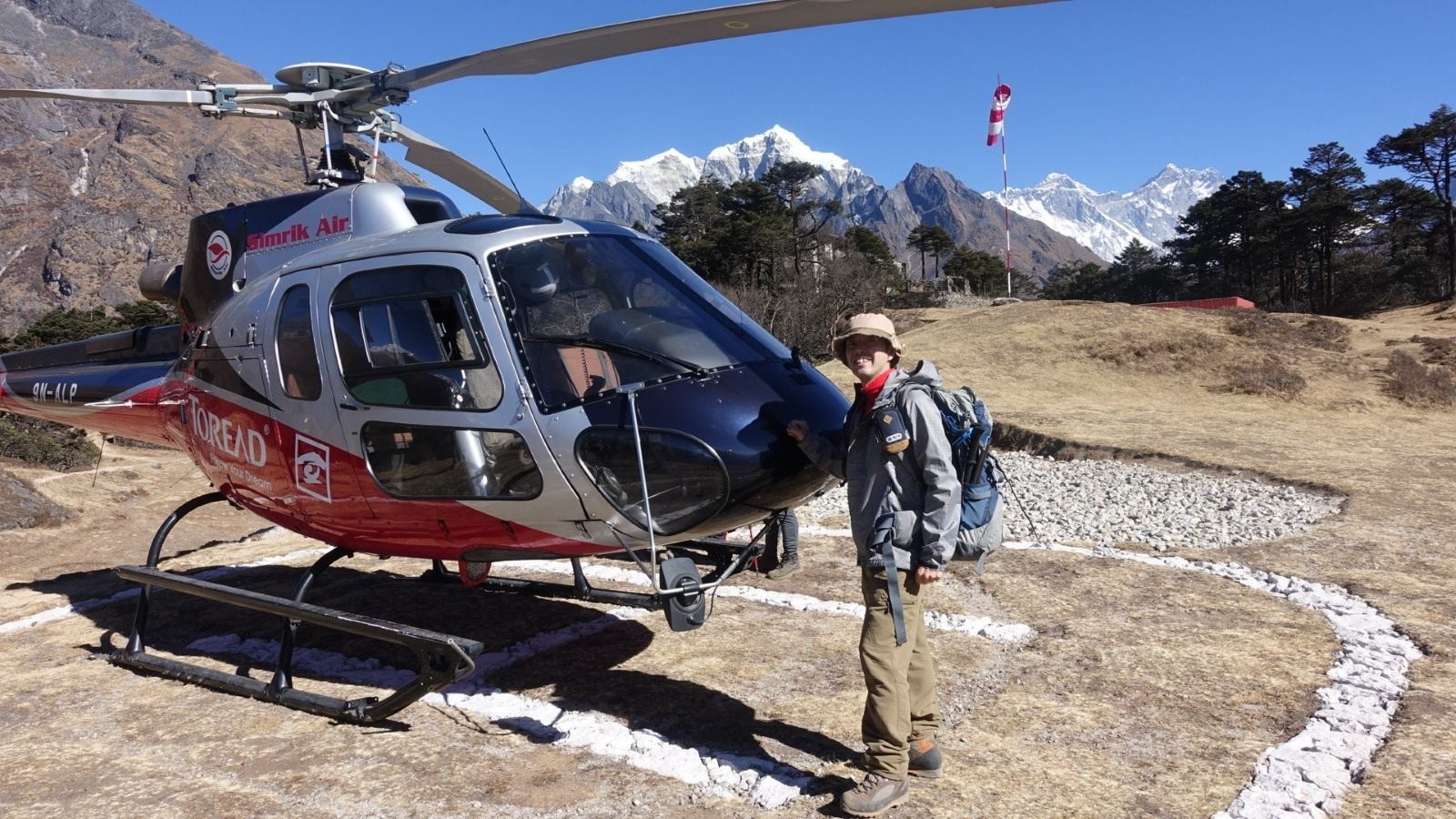 Helicopter landing near the Everest View Hotel in Syangboche, with panoramic views of Mount Everest, Ama Dablam, Lhotse, and the surrounding Himalayan peaks under a clear blue sky.