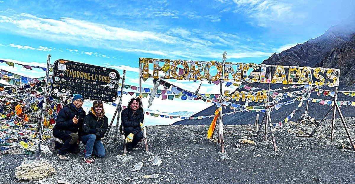 Thorong La Pass (5,416 m) with colorful prayer flags, snow-covered mountain trails, and breathtaking panoramic views of the Annapurna and Dhaulagiri Himalayan ranges in Nepal.