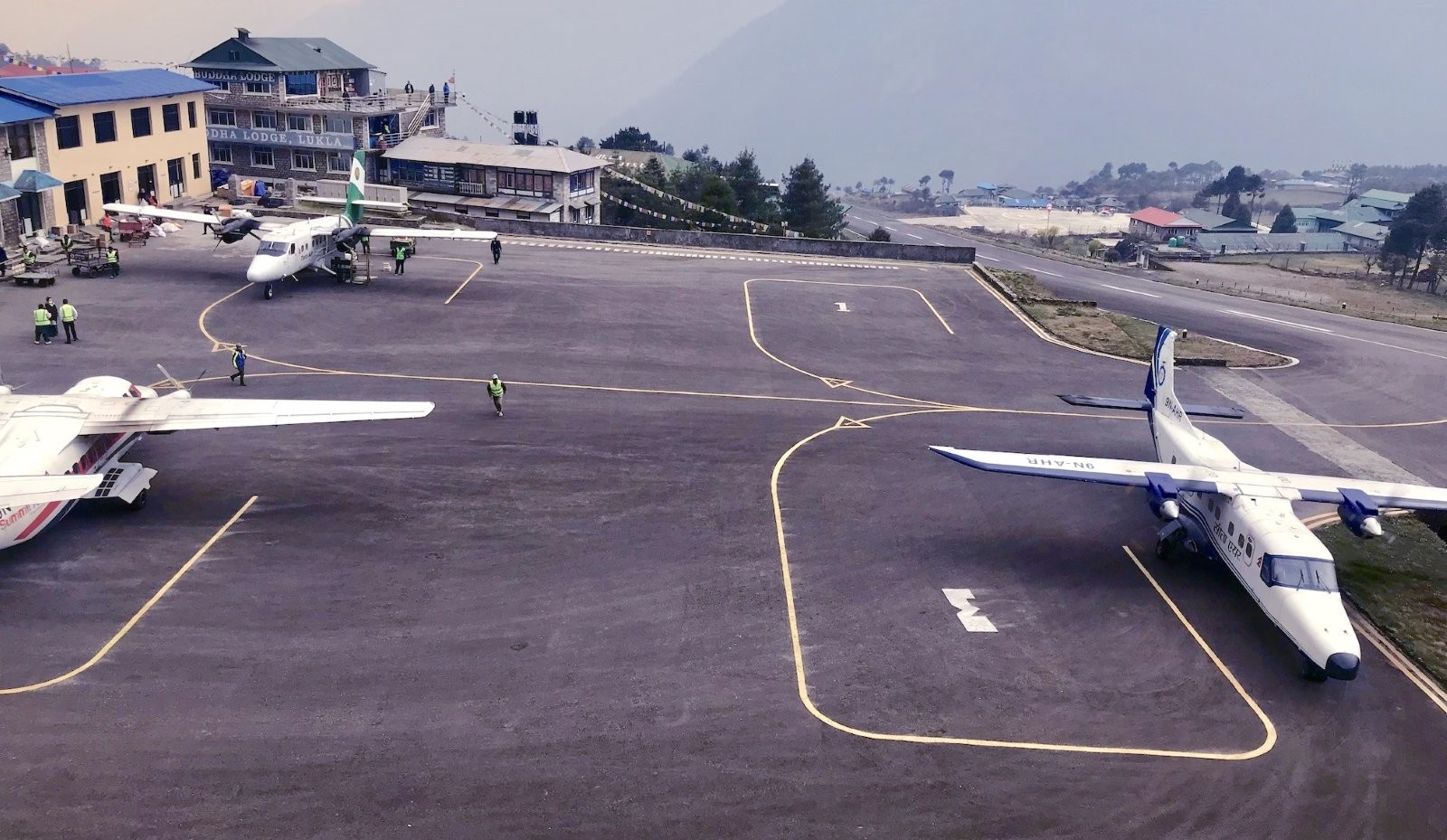 "Aircraft landing at Lukla Airport with the dramatic Himalayan mountains surrounding the gateway to the Everest Base Camp Trek"