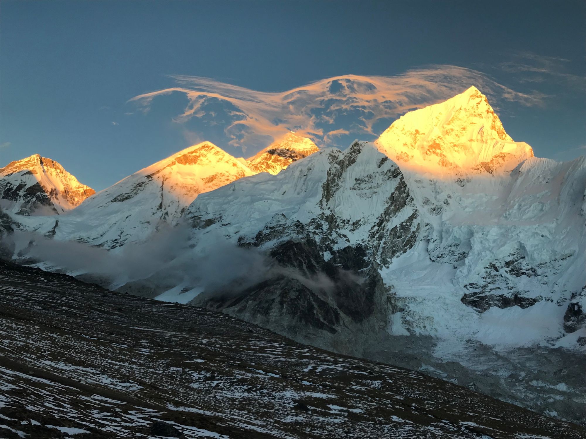 Golden sunset from Kala Patthar illuminating Mount Everest, Nuptse, and the Khumbu Glacier with glowing snow-covered Himalayan peaks.
