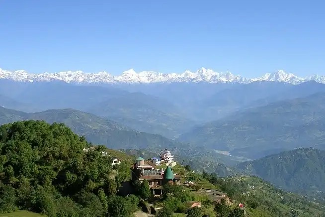 Panoramic mountain view from Nagarkot featuring the Himalayan range, including Langtang, Ganesh Himal, Dorje Lakpa, Gaurishankar, and Everest on a clear morning above lush green hills.