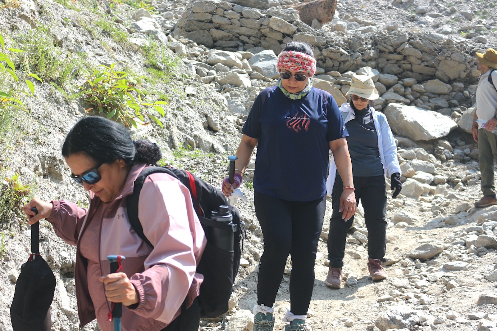 Trekkers walking across a rocky trail in Langtang Valley during spring