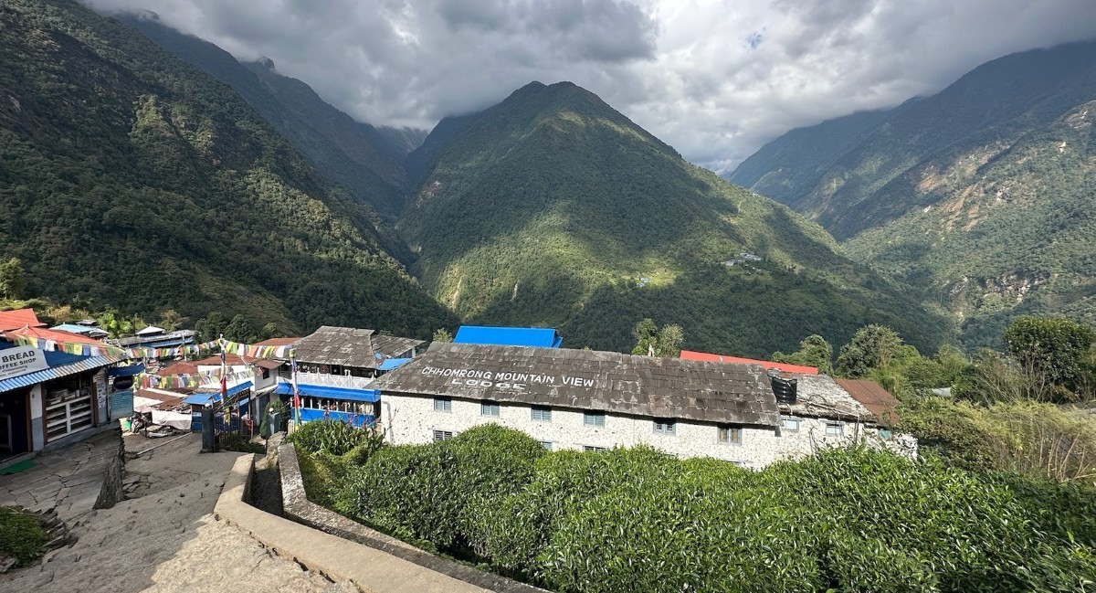 Traditional Chhomrong village nestled on a hillside with stone houses, terraced fields, and stunning views of Annapurna South and Machhapuchhre along the Annapurna Base Camp Trek via Poon Hill.