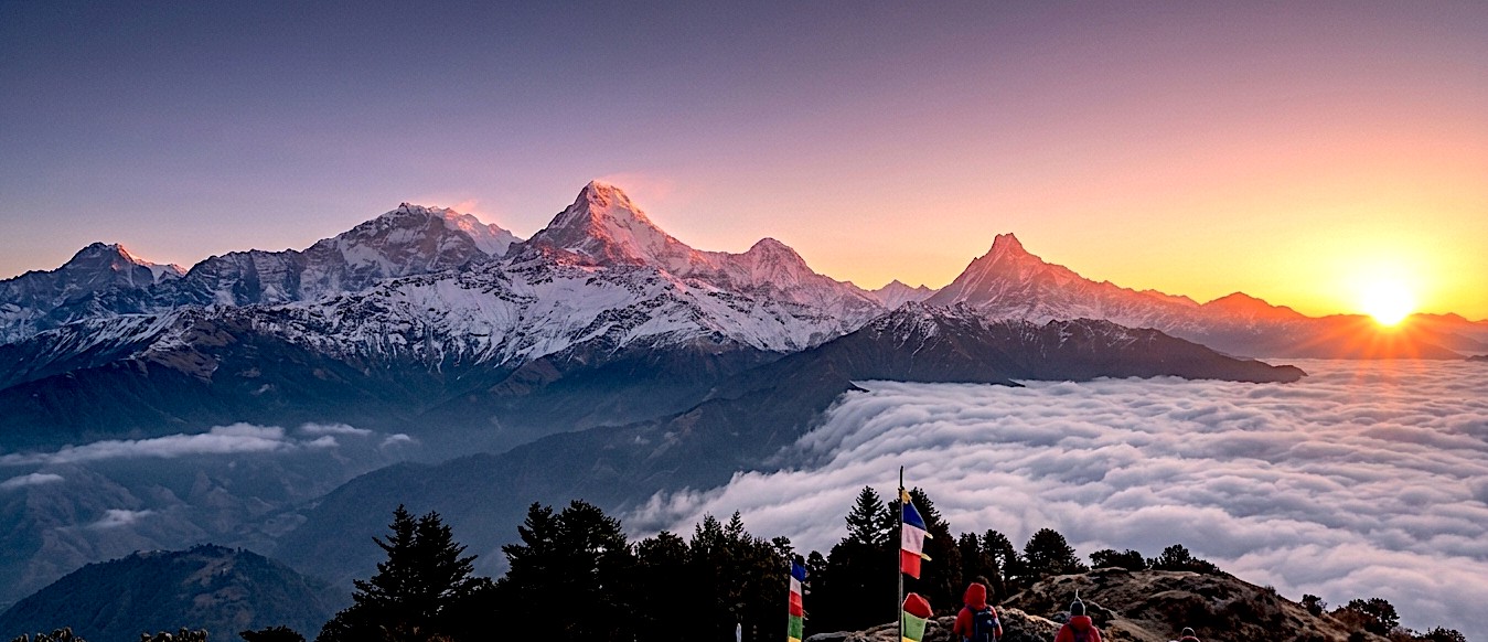 Panoramic sunrise view from Muldai Viewpoint or Khopra Danda featuring Dhaulagiri, Annapurna South, Nilgiri, Machhapuchhre (Fishtail), and the Annapurna range above rolling green hills.