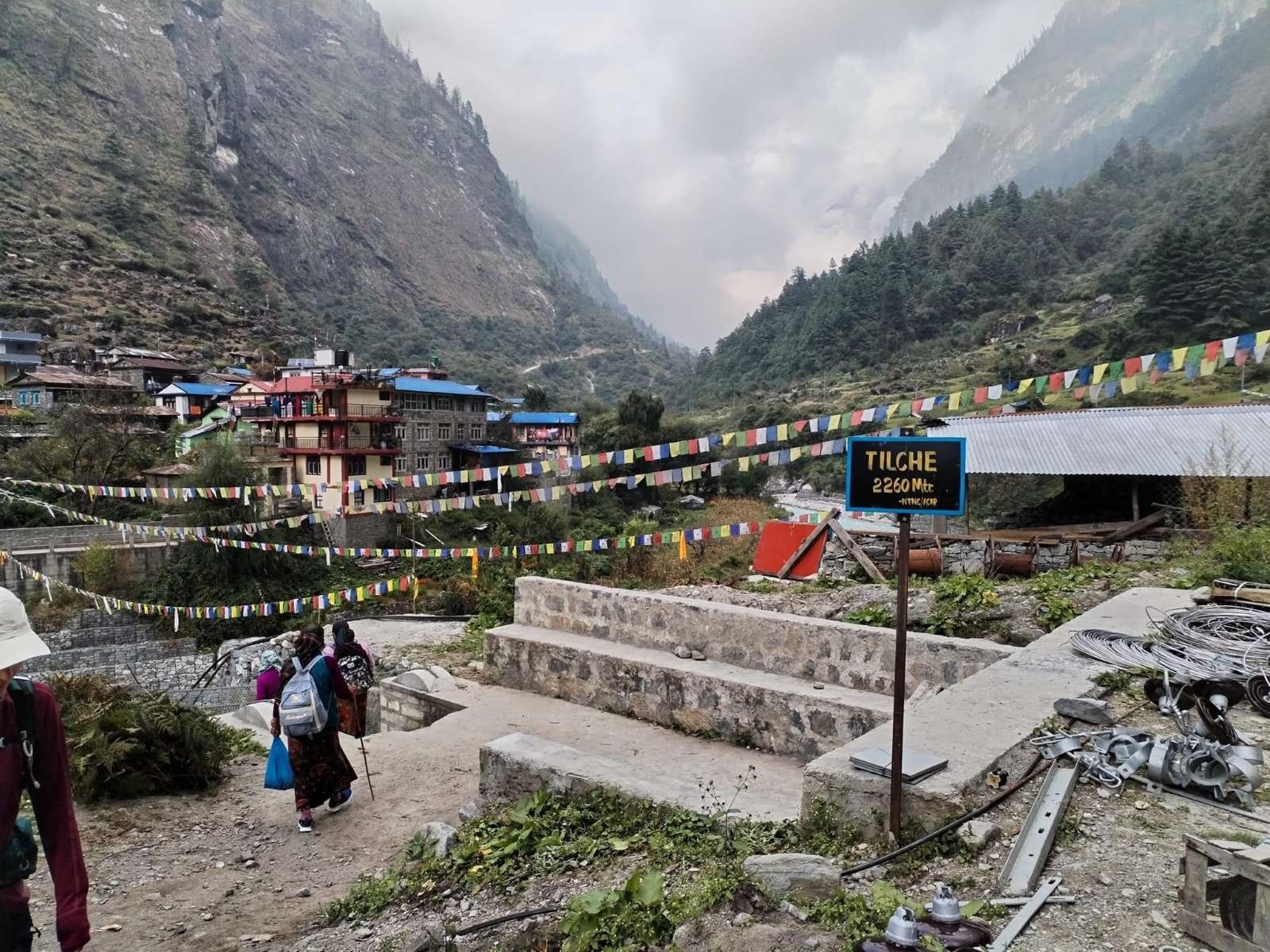 Traditional view of Tilche featuring stone houses, terraced fields, pine forests, and scenic Himalayan mountain landscapes along the Manaslu Circuit Trek route.