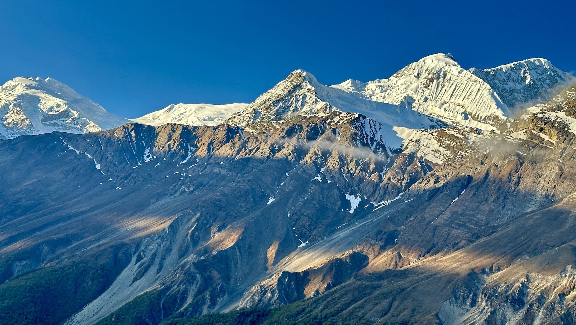 Panoramic view of the Annapurna Range from Manang, featuring snow-covered Himalayan peaks, deep valleys, and traditional mountain landscapes in Nepal.