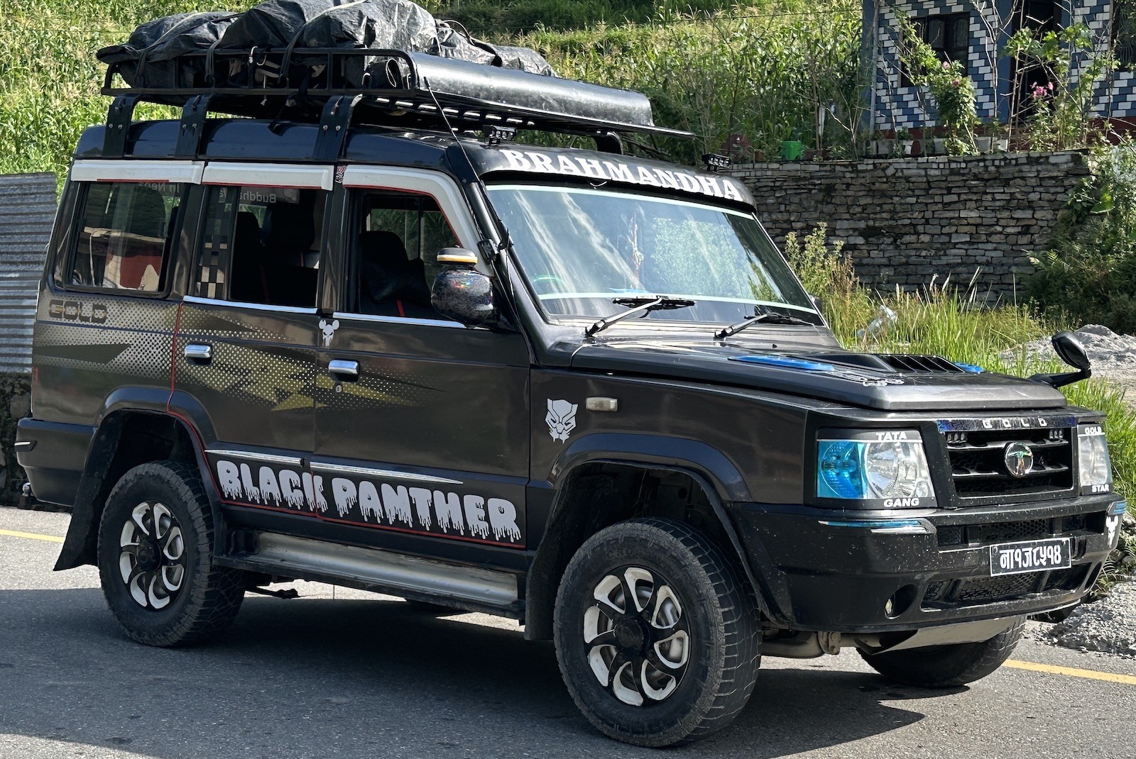 Jeep on a mountain road near Kalimati Village, a small settlement in the Annapurna region of Nepal that serves as a possible starting or ending point for the Mardi Himal Trek, surrounded by green hills and terraced fields.