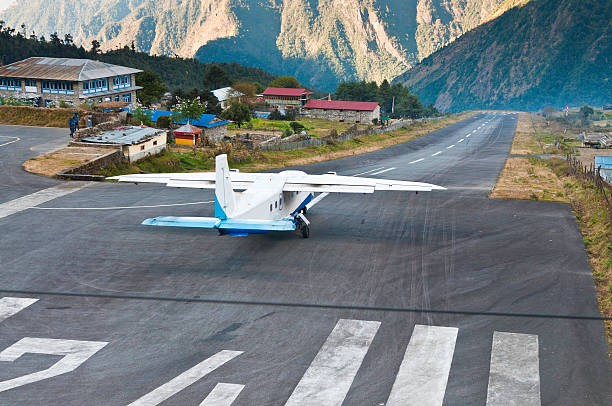 Small aircraft taking off from Lukla Airport with Himalayan mountains during the flight back to Kathmandu, Nepal.