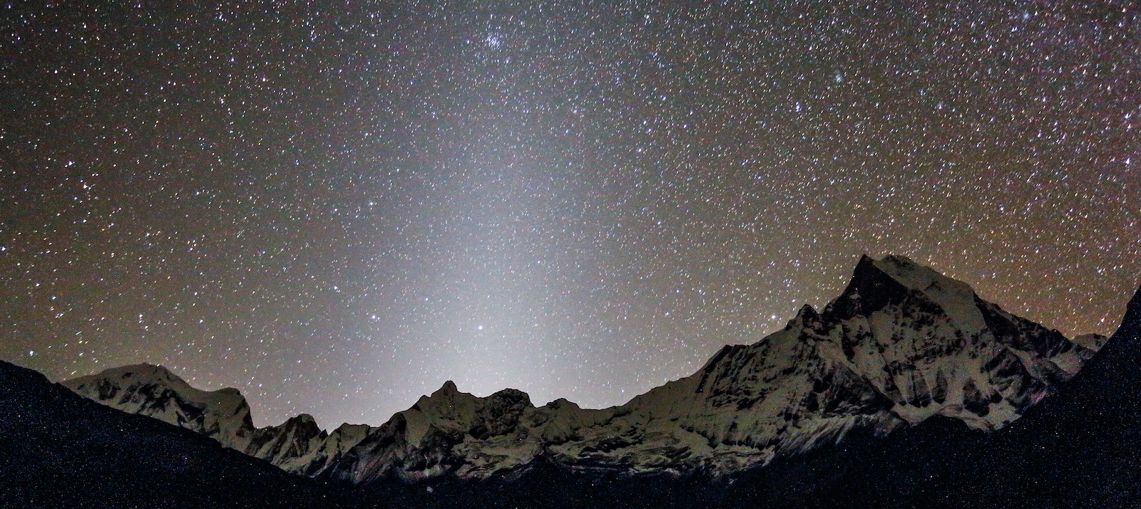 Brilliant star-filled night sky above the Annapurna Base Camp with the silhouette of Machhapuchhre (Fishtail) and surrounding Himalayan peaks, creating an unforgettable October stargazing experience in Nepal.