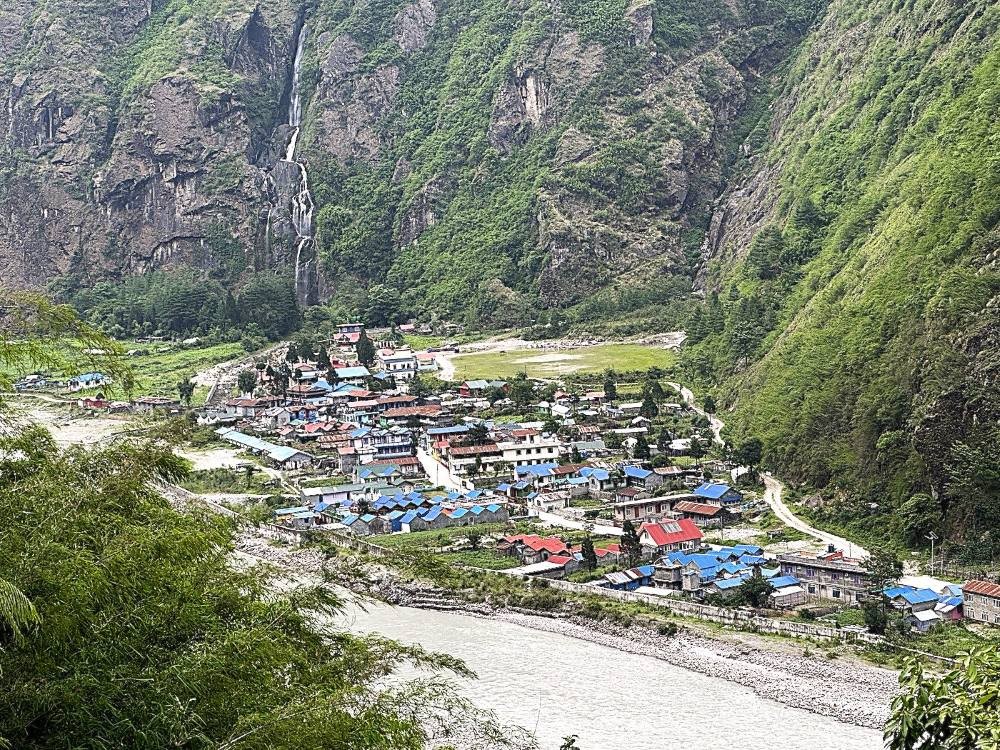 Tal Village on the Annapurna Circuit Trek featuring traditional stone houses, the Marsyangdi River, dramatic waterfalls, towering cliffs, lush forests, and spectacular Himalayan scenery in Nepal.