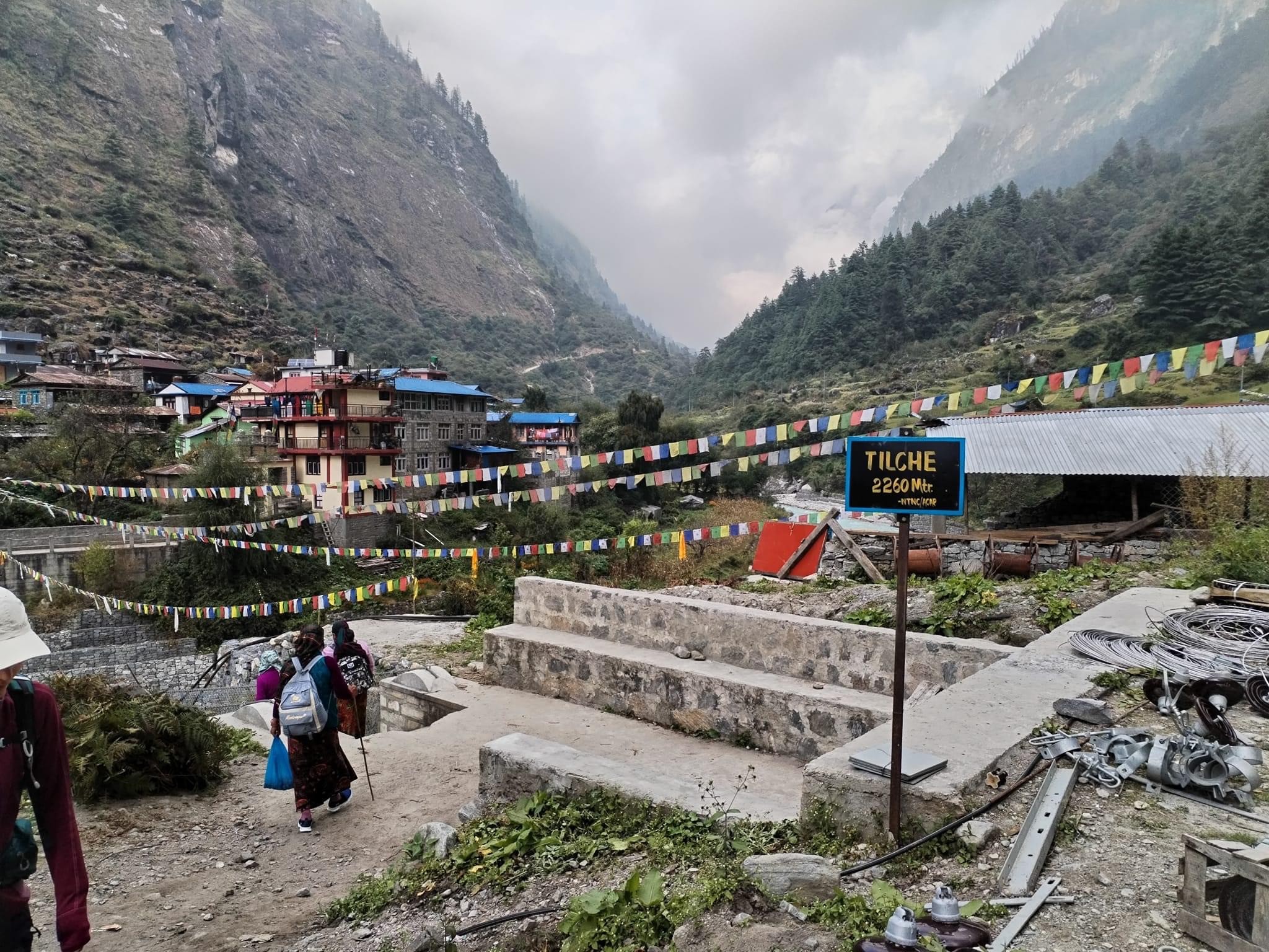 Traditional view of Tilche featuring stone houses, terraced fields, pine forests, and scenic Himalayan mountain landscapes along the Manaslu Circuit Trek route.
