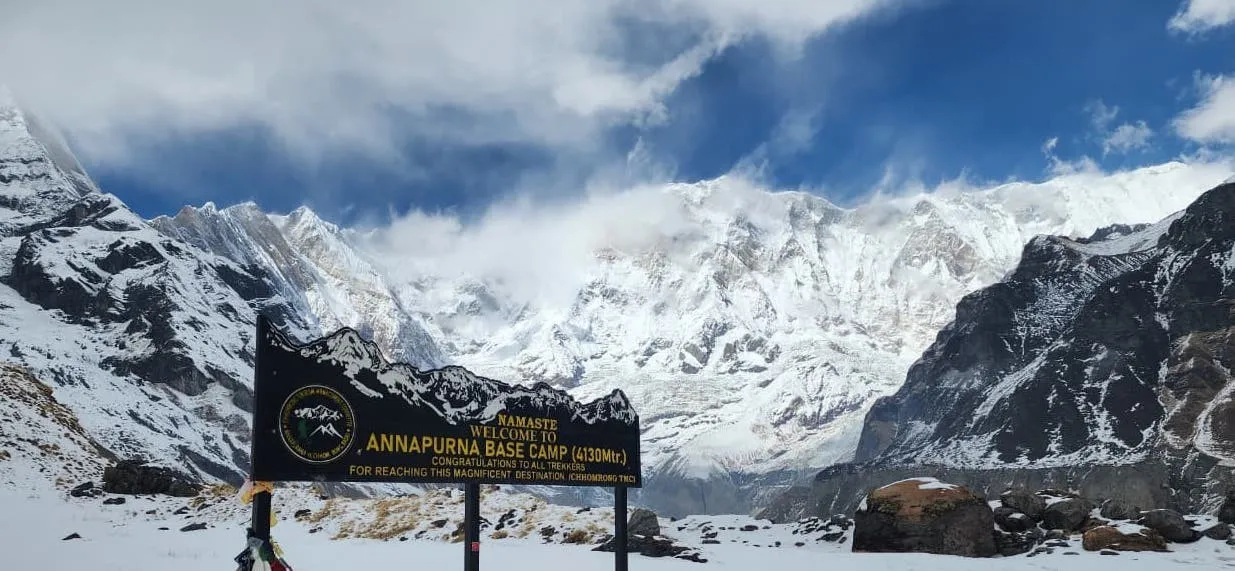 Annapurna Base Camp nestled in the heart of the Annapurna Sanctuary, surrounded by towering snow-capped peaks including Annapurna I, Annapurna South, Hiunchuli, and Machhapuchhre, with mountain lodges and breathtaking Himalayan scenery.