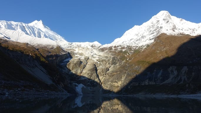 Snow-covered peak of Mount Manaslu under clear blue sky