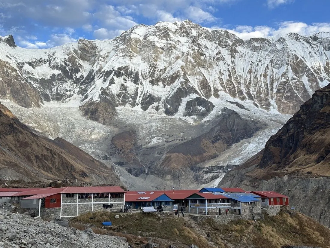 Mountain lodge at Annapurna Base Camp surrounded by snow-covered Himalayan peaks and dramatic alpine scenery in Nepal.