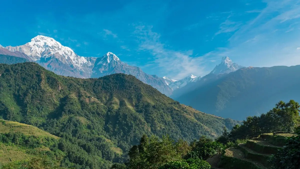 Panoramic view of the Annapurna range seen from Ghandruk with snow-capped Himalayan peaks rising above traditional Gurung village landscapes.