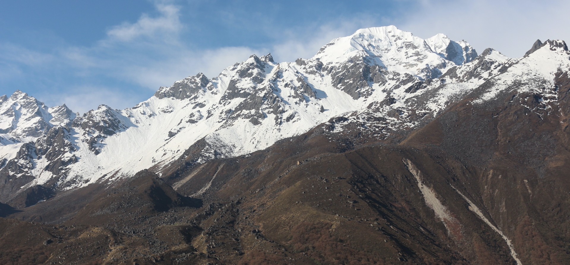 Panoramic mountain view during the Langtang Valley Trek in spring, featuring snow-capped Himalayan peaks