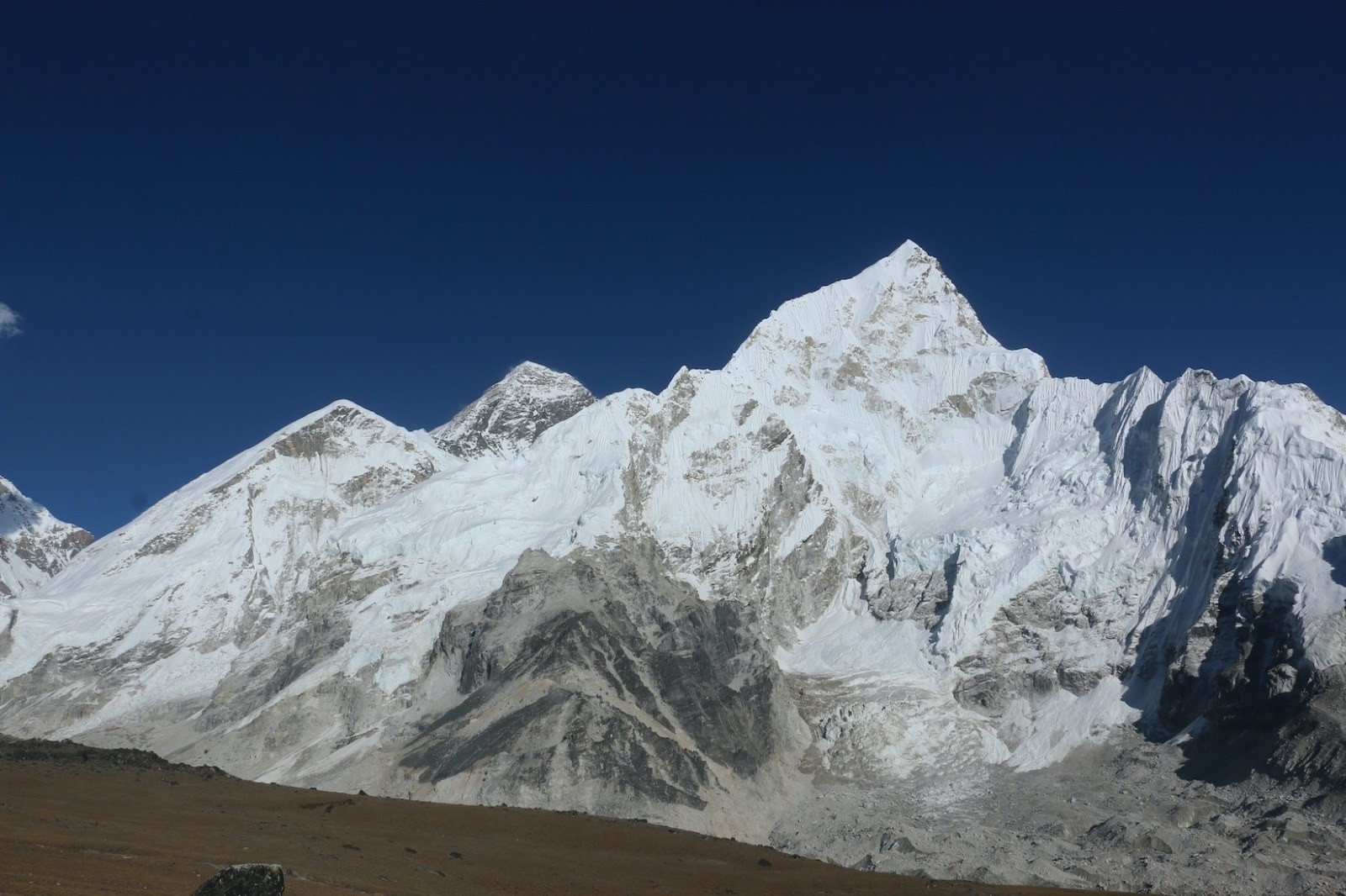 Panoramic view from Kala Patthar featuring Mount Everest, Nuptse, Lhotse, Pumori, and the Khumbu Glacier under a crystal-clear Himalayan sky.
