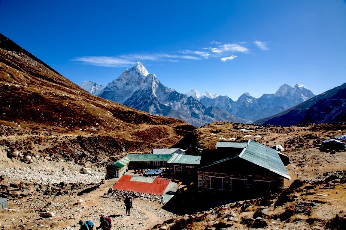 "Thukla Pass memorial area with stone monuments, rugged alpine terrain, and towering Himalayan peaks on the Everest Base Camp Trek in Nepal"