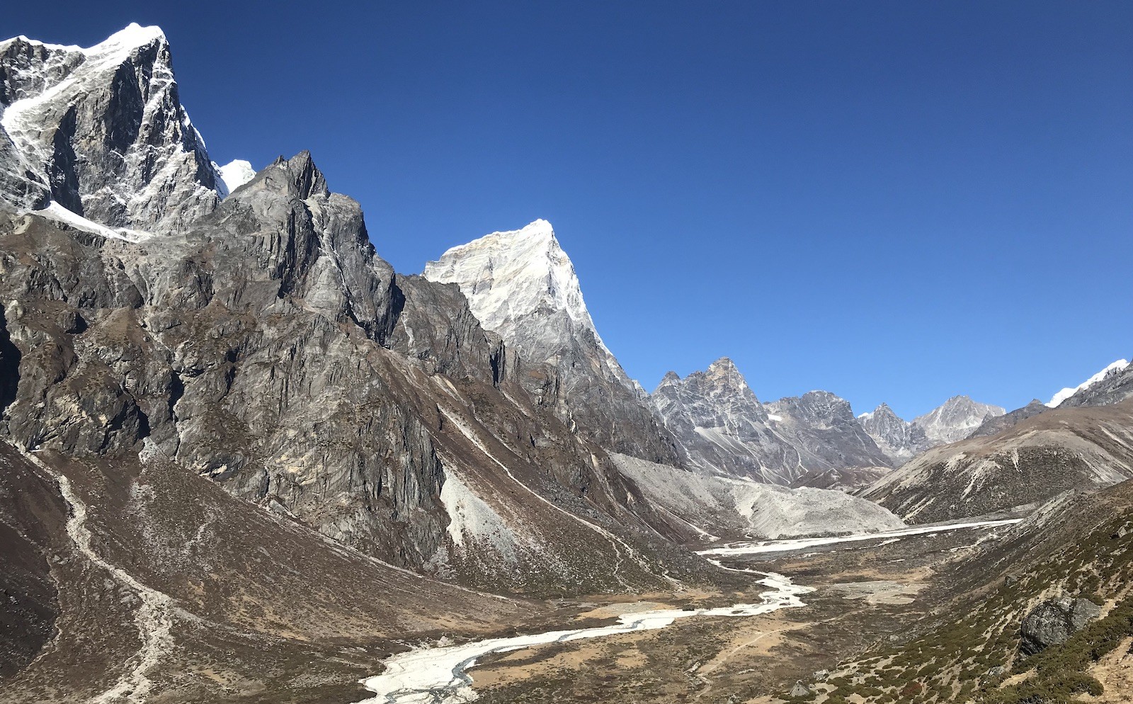 Dry and well-defined trekking trail through the Pheriche Valley in the Everest region, with clear skies, open landscapes, and surrounding Himalayan peaks in November.