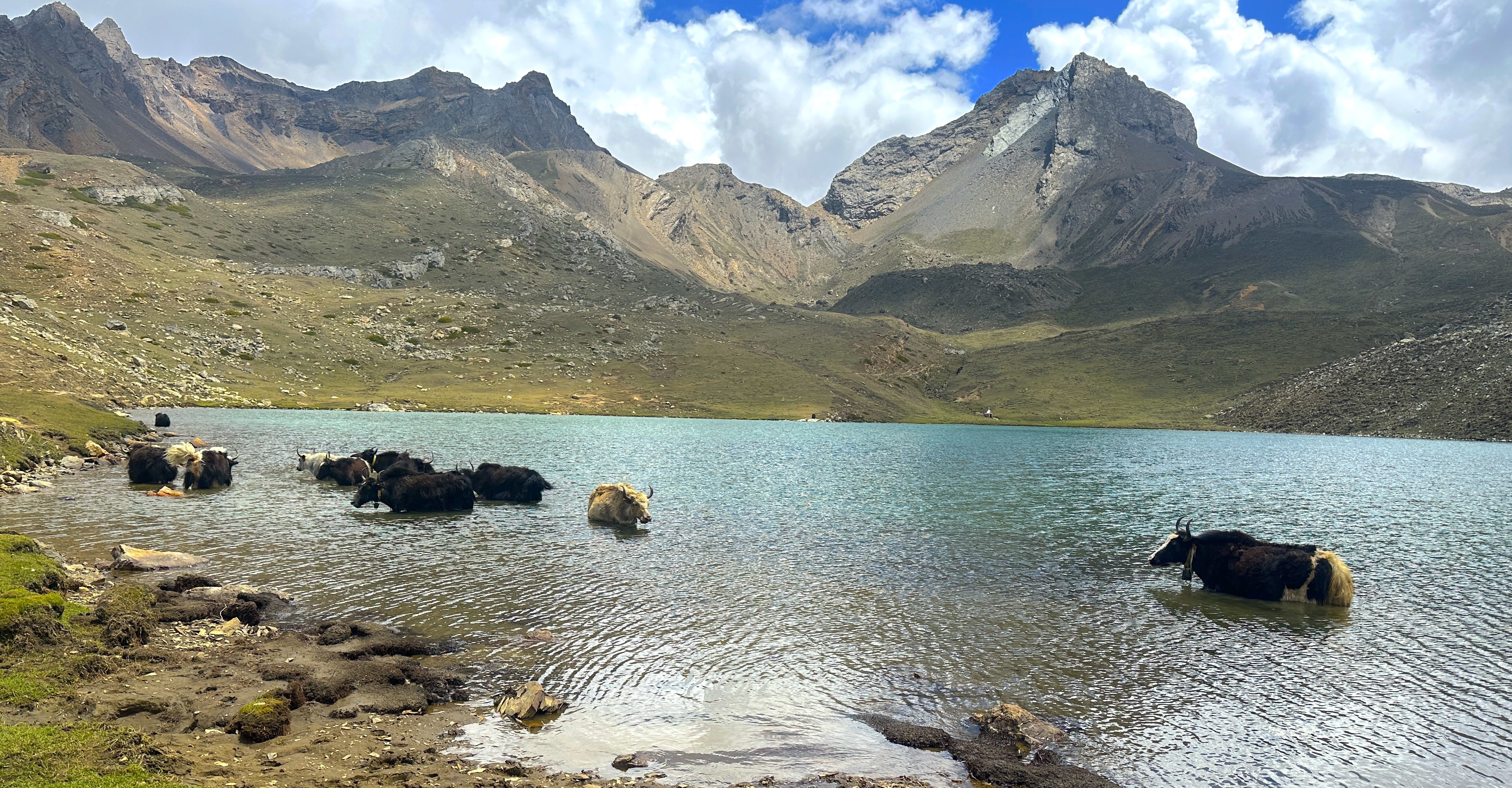 Alpine glacial lake in the Manang region of Nepal showing a frozen or icy surface surrounded by rugged Himalayan peaks and high-altitude terrain used for acclimatization side hikes near Manang.