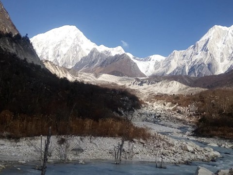 Glacial river flowing through valley with mountain backdrop