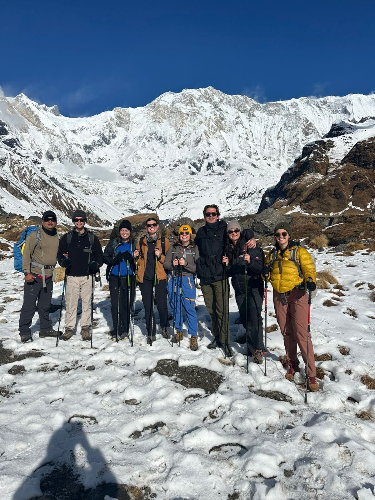 Winter Annapurna Base Camp Trek with trekkers standing in deep snow beneath snow-covered Himalayan peaks.