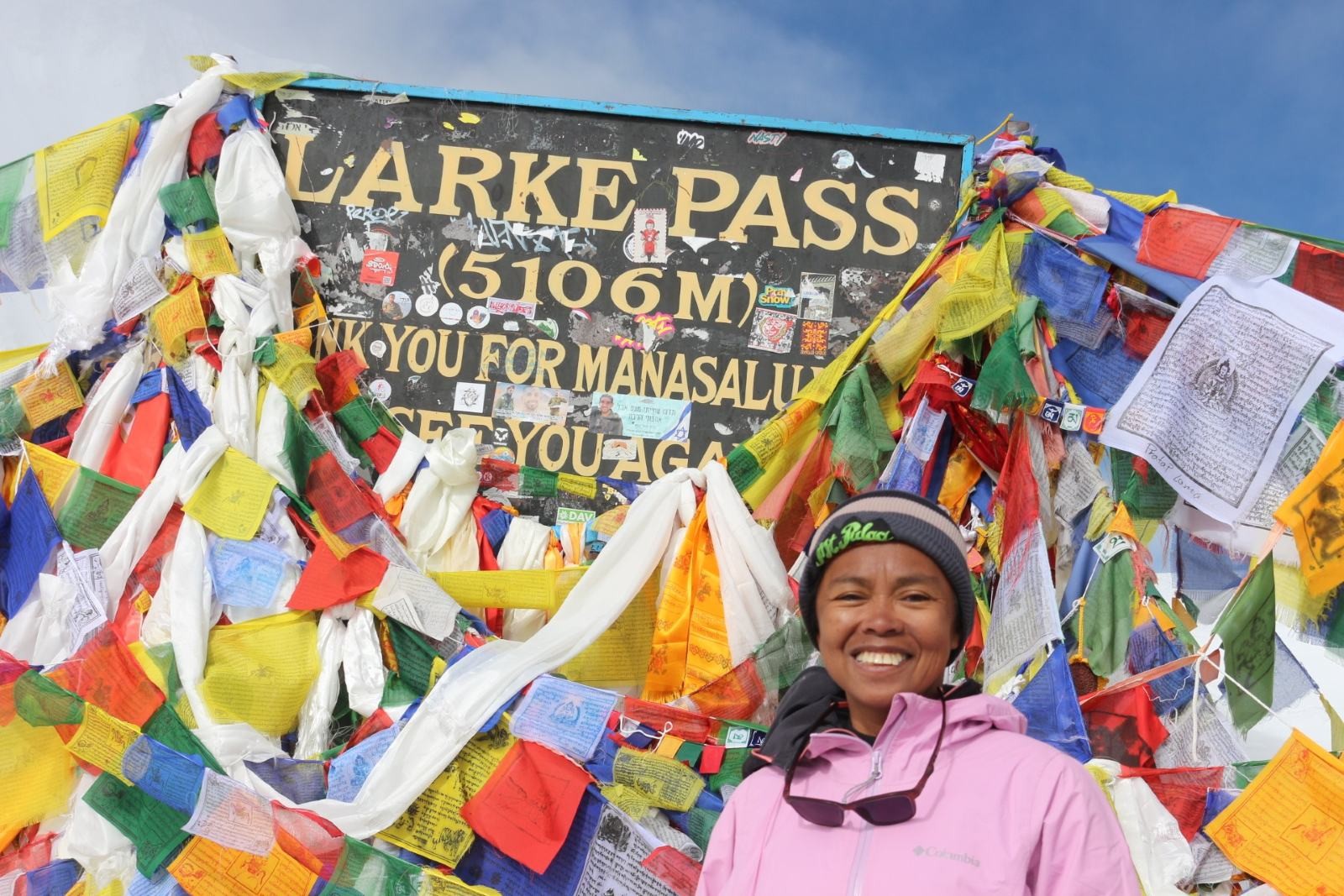 High-altitude scenery at Larke Pass featuring snowy peaks and Tibetan prayer flags in the Manaslu region.