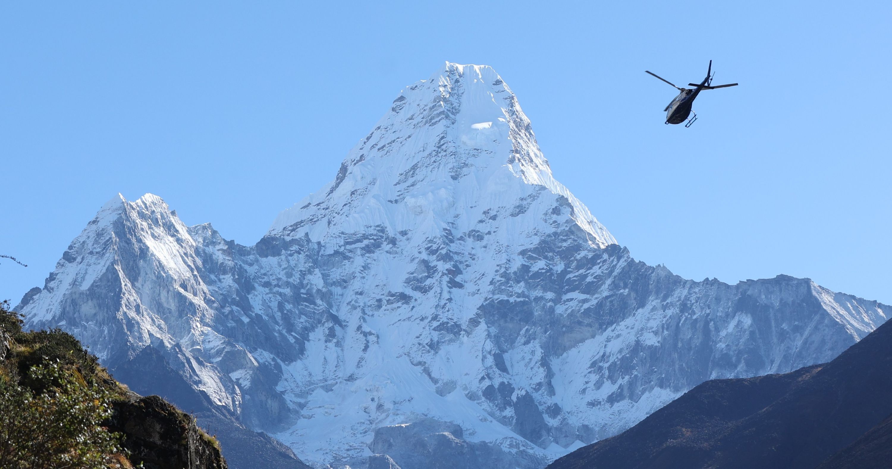 Helicopter flying above the Khumbu Valley with Mount Ama Dablam rising in the background during the Everest Base Camp Trek.