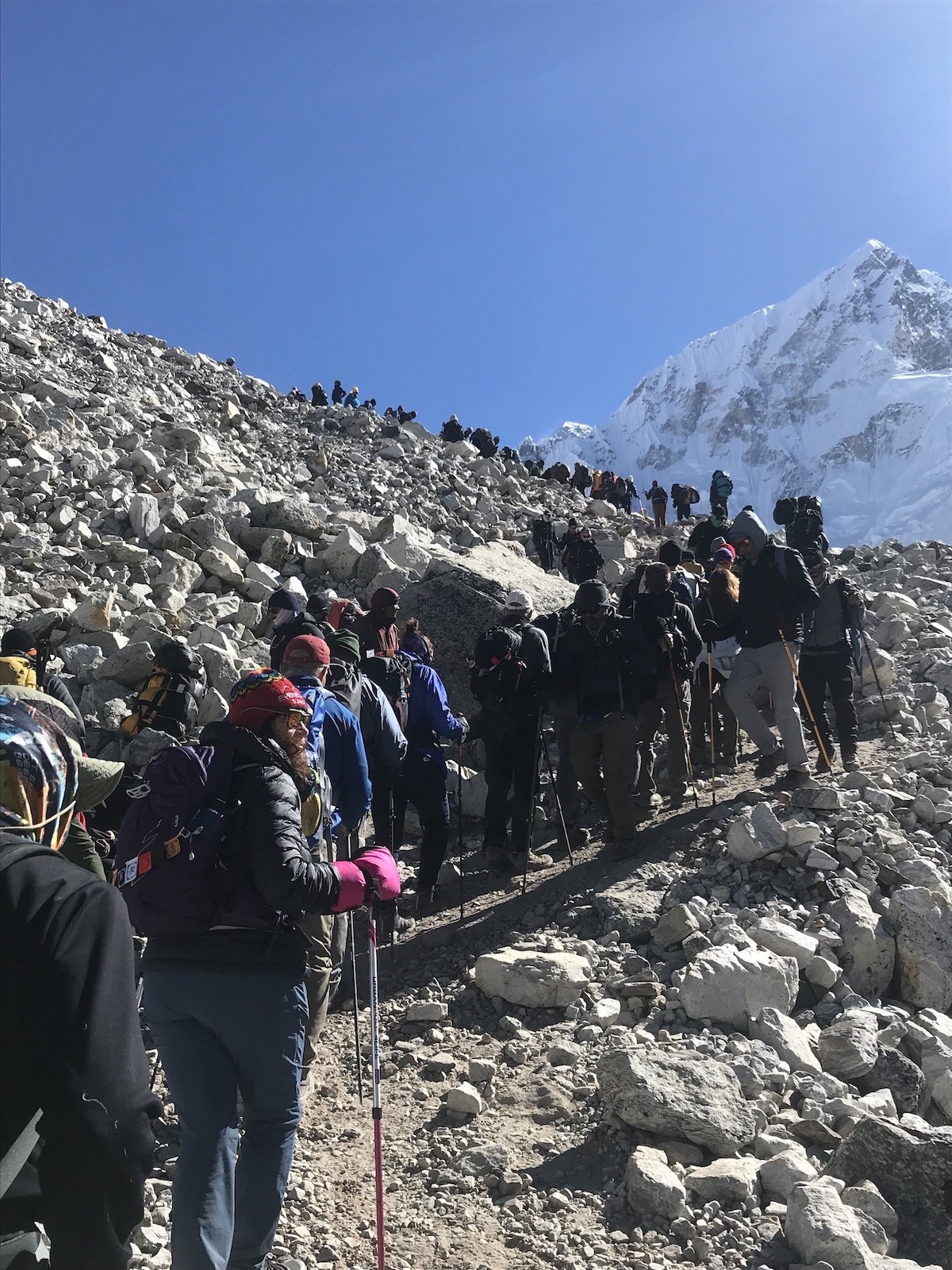 "Busy Everest Base Camp trail crowded with international trekkers walking through the Khumbu region during peak trekking season, with Himalayan mountains in the background" Photo