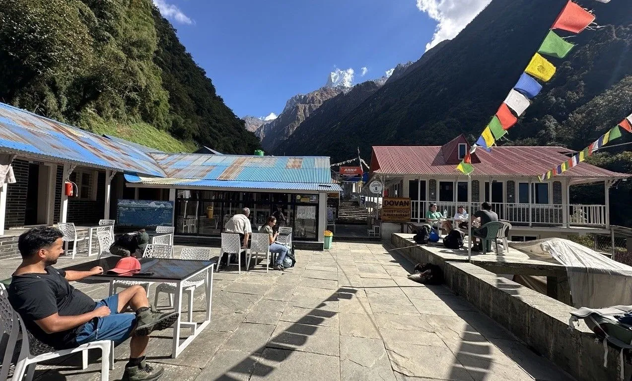Dovan lodges nestled among dense bamboo and rhododendron forests, surrounded by steep Himalayan hillsides, waterfalls, and peaceful mountain scenery on the Annapurna Base Camp Trek.