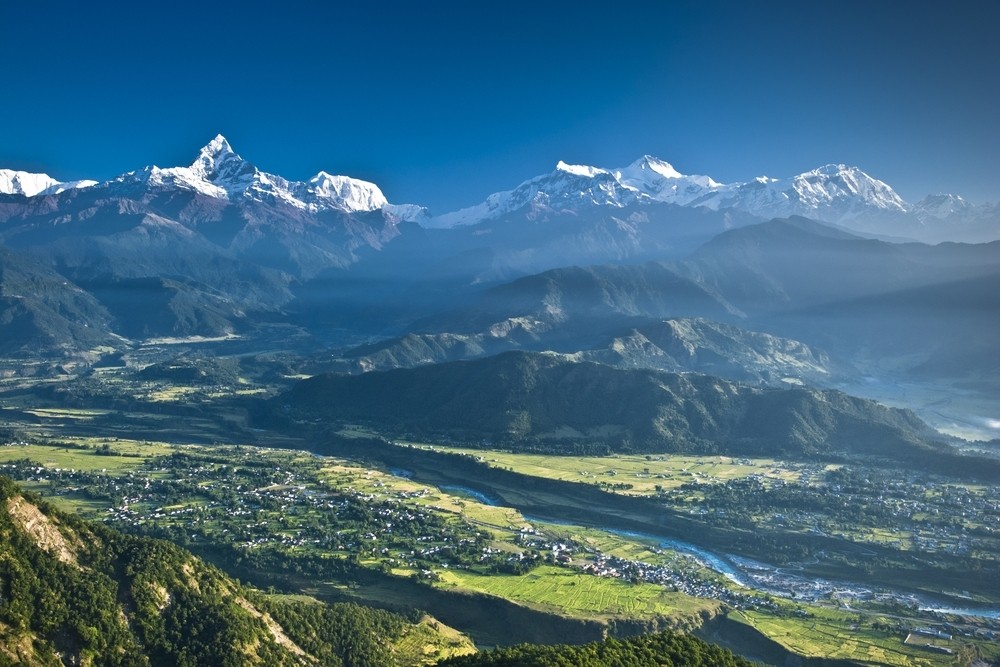 Panoramic Himalayan mountain range and lush valley viewed from Sarangkot near Pokhara, Nepal.