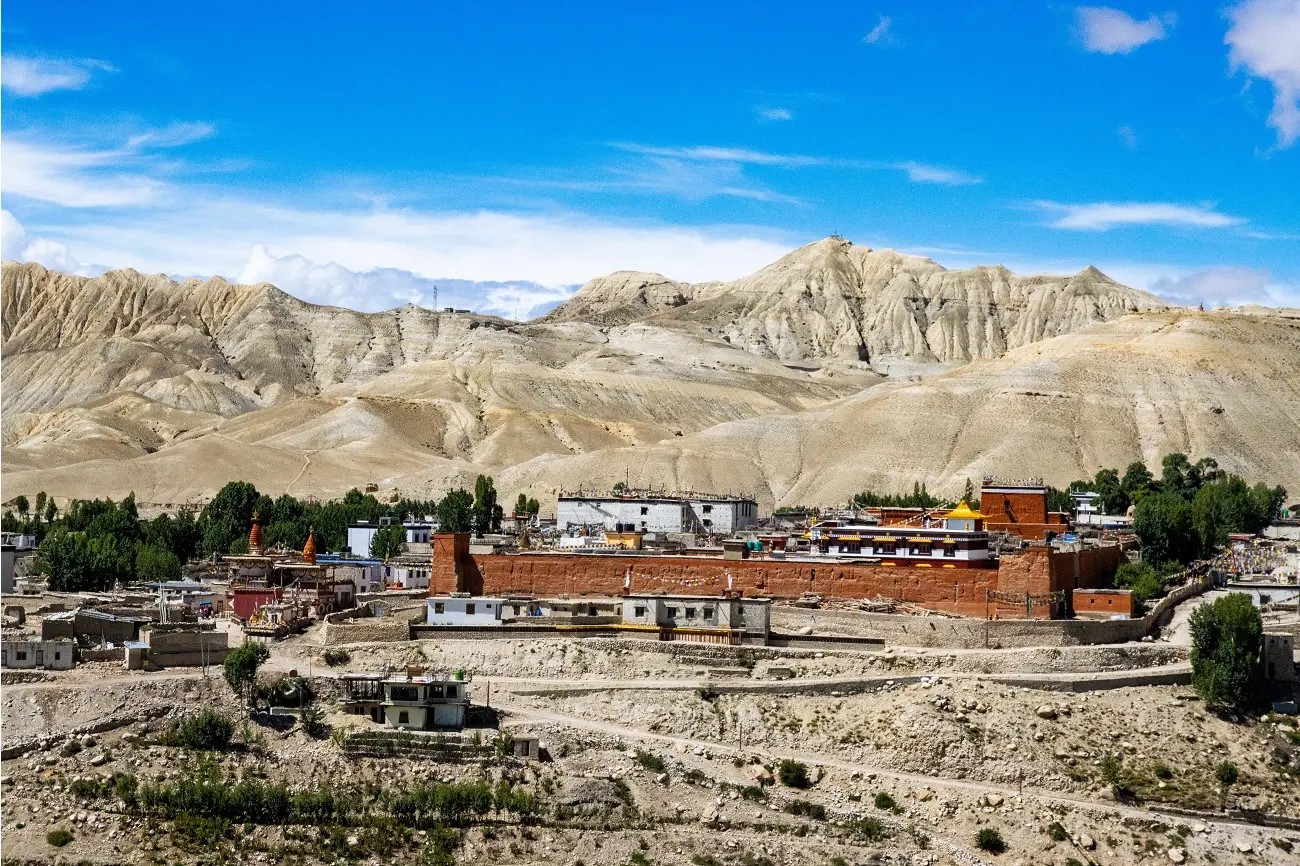 A breath-taking September view of Upper Mustang with colourful barren cliffs, ancient Tibetan-style villages, dramatic desert valleys, and snow-capped Himalayan peaks beneath crystal-clear post-monsoon skies.