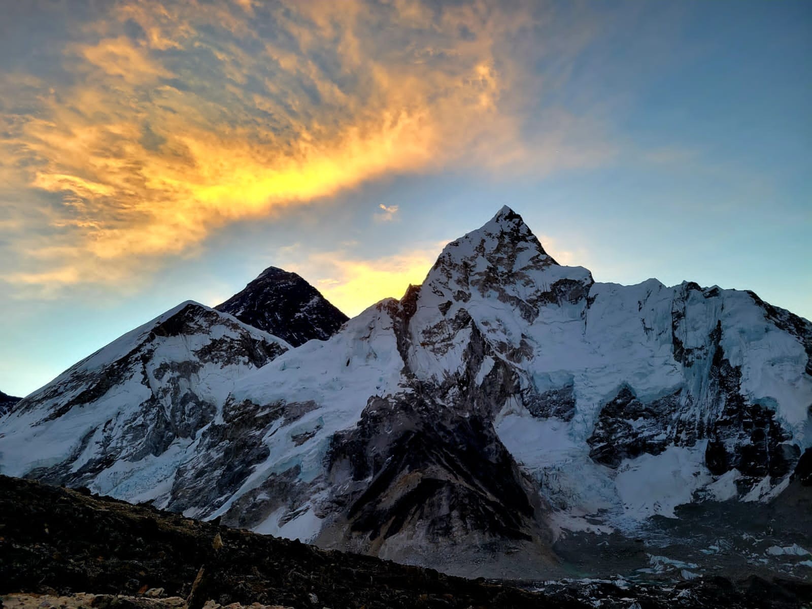 Sunrise over Mount Everest from Kala Patthar with golden light illuminating snow-covered Himalayan peaks in Nepal.