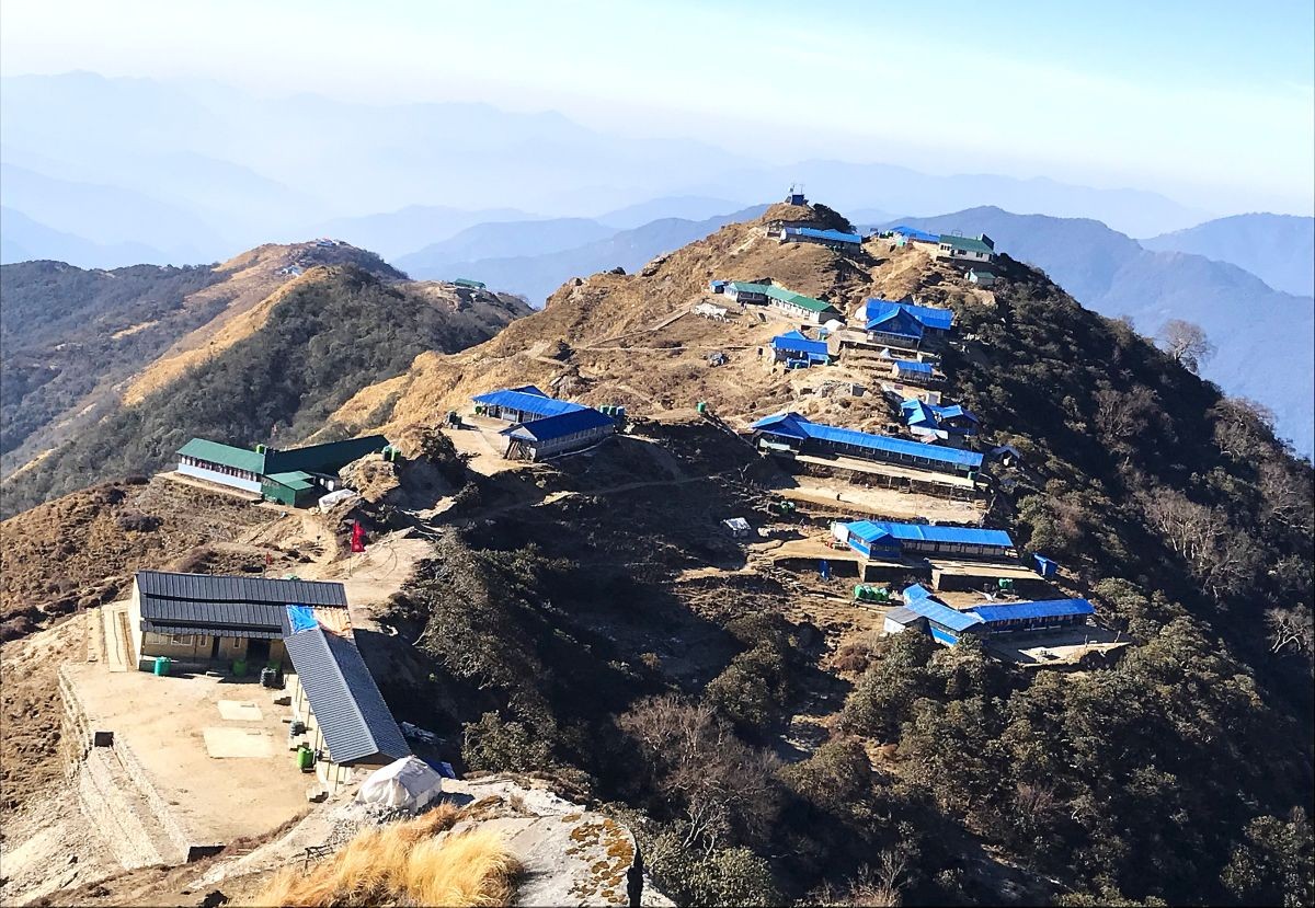 Traditional teahouse lodges at Mardi Himal High Camp with panoramic views of Machhapuchhre (Fishtail), Annapurna South, and the surrounding Himalayan peaks, Nepal.