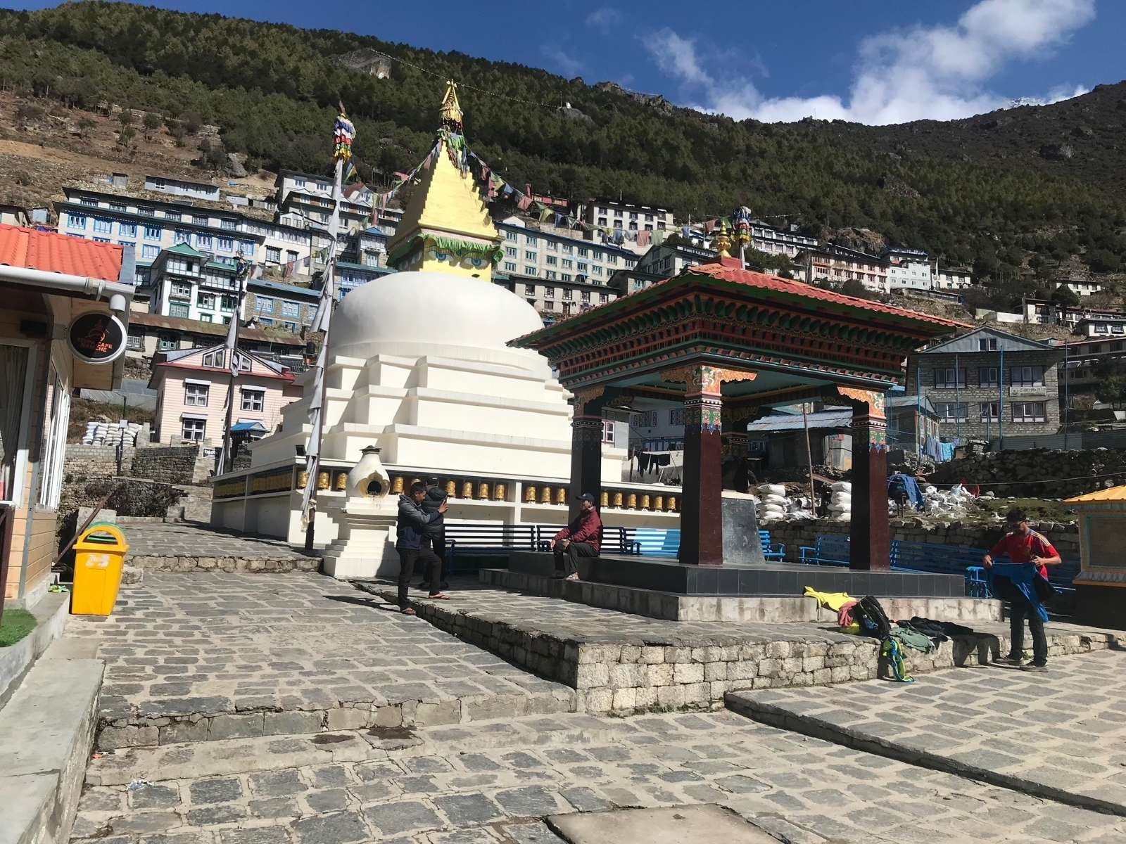 Namche Bazaar stupa with colorful prayer flags overlooking the vibrant Sherpa town, surrounded by spectacular views of Kongde Ri, Thamserku, and the Himalayan mountains on the Everest Base Camp Trek.