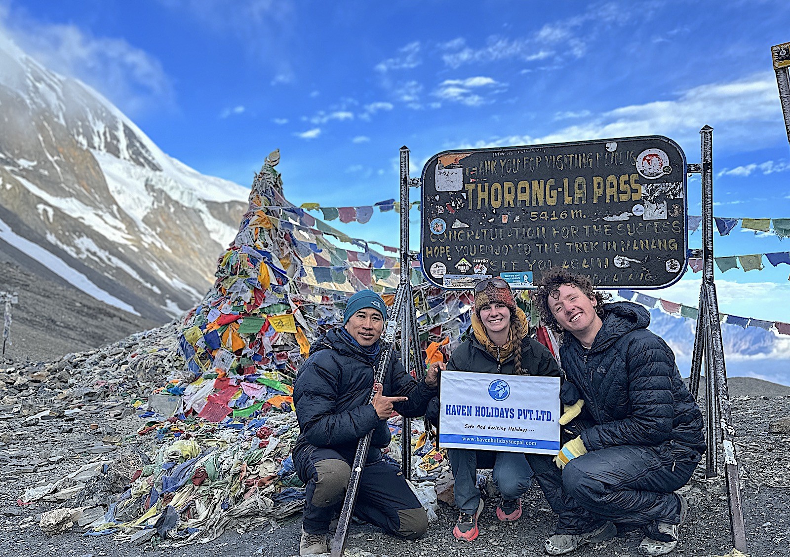Summit of Thorong La Pass on Annapurna Circuit Trek in Nepal with prayer flags and Himalayan mountain views