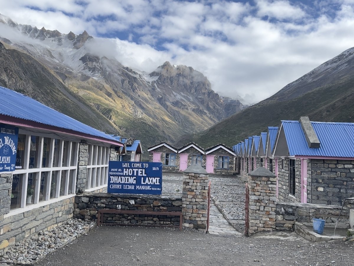Traditional mountain guesthouse on the Annapurna Circuit Trek with cozy stone-and-wood construction, comfortable rooms, a welcoming dining hall, and stunning Himalayan mountain views in Nepal.