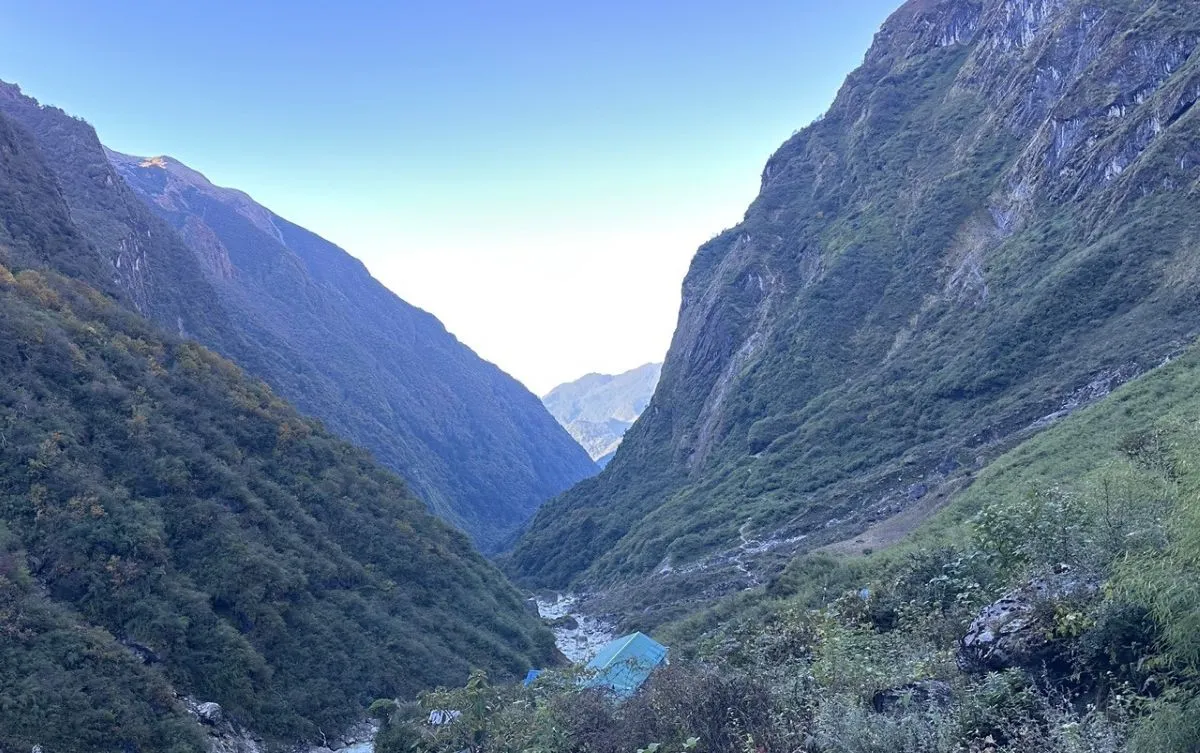 View looking down the deep valley from Deurali on the Annapurna Base Camp Trek, featuring the Modi Khola gorge, steep forested slopes, waterfalls, and dramatic Himalayan landscapes.