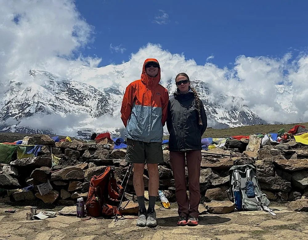 Trekker standing on stable mountain trail during October trekking season in Nepal with clear weather and solid footing”